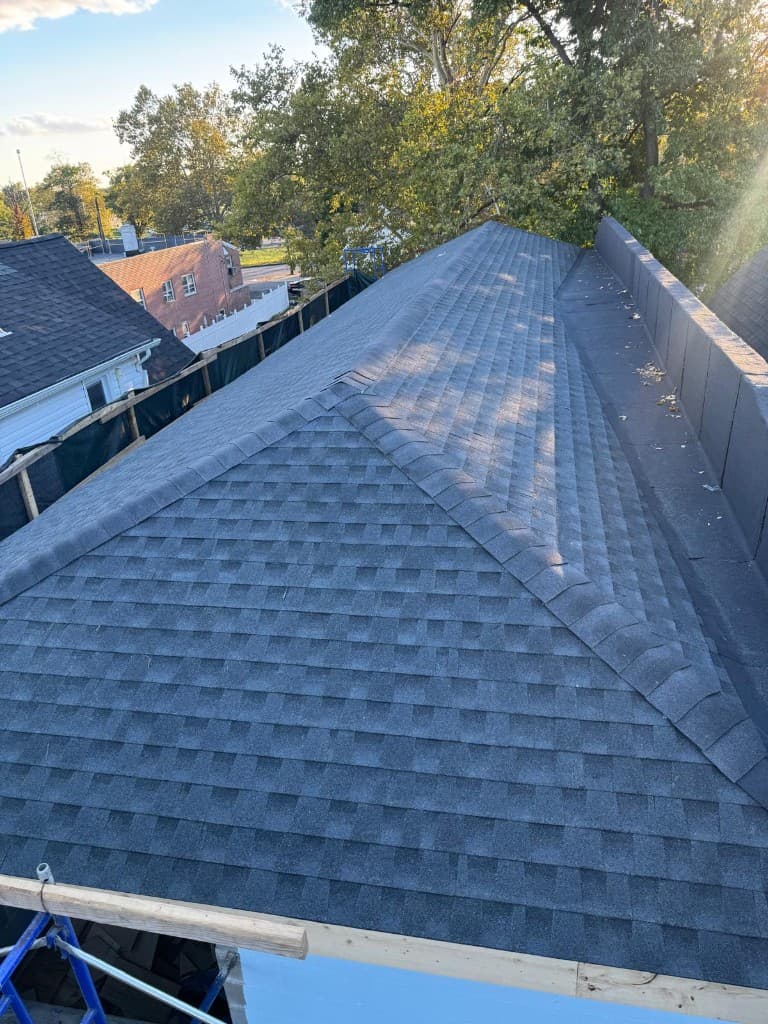 Finished hip roof with new architectural shingles, ridge and hip caps and a membrane-covered section on one side