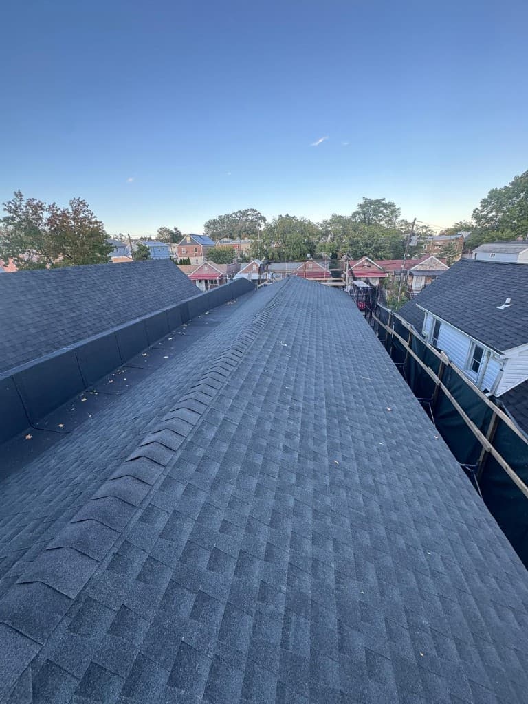 New architectural shingle roof with a ridge cap and a membrane-covered section along the edge