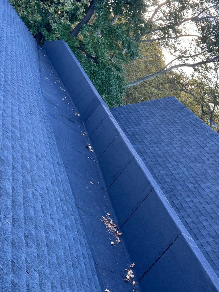 Close view of a membrane-covered section with lapped seams beside new roof shingles