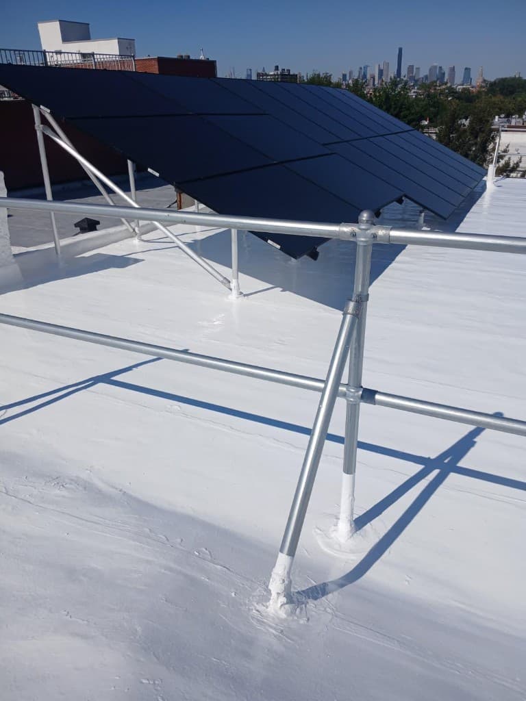 Finished white silicone coating around aluminum guardrail posts and solar-array legs, each base sealed with coating