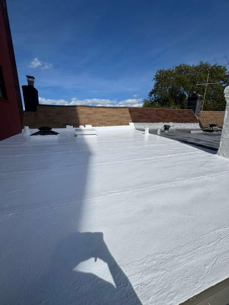 Finished white coating on a flat roof with skylights and vents sealed